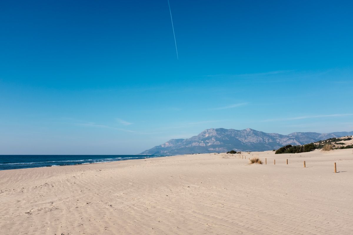 The long dune-backed golden sand of Patara Beach with mountains behind, on Turkey's western Lycian coast